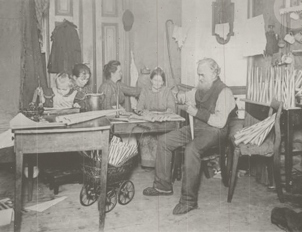 A faded, scratched family photograph from around 1900, before restoration
